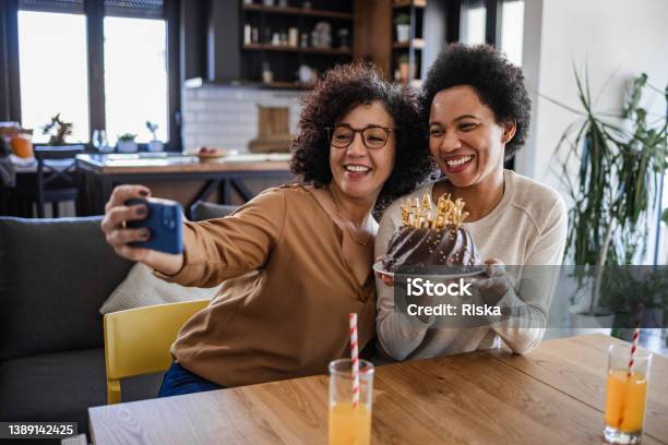 Lesbian Latin American Woman Posing With Her Partner While Holding A Birthday Cake Stock Photo - Download Image Now