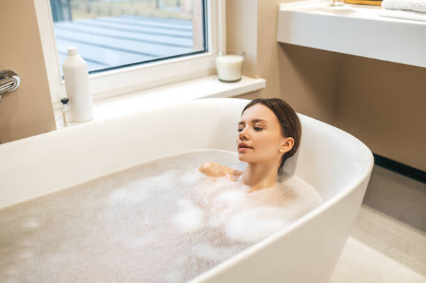 istock Pretty lady taking a relaxing bath at home 1389142514