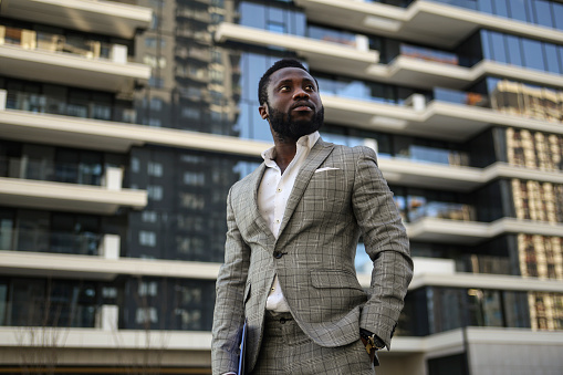 Mid adult businessman in a modern city. About 30 years old, African male.