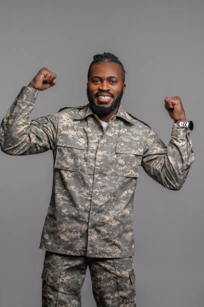 istock Uniformed guy with clenched fists standing by the wall 1389146223
