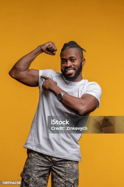 Pleased Young Man Demonstrating His Physical Strength Stock Photo - Download Image Now