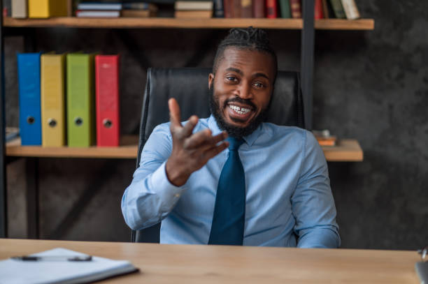 istock Cheerful elegant entrepreneur sitting at his office desk 1389146300