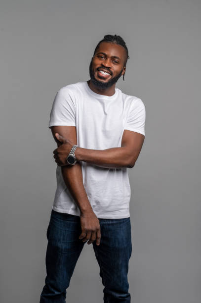 istock Happy guy with his wristwatch standing by the gray wall 1389146310