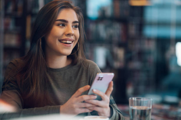 istock Woman using smartphone and drinking coffee in a cafe. 1389147191