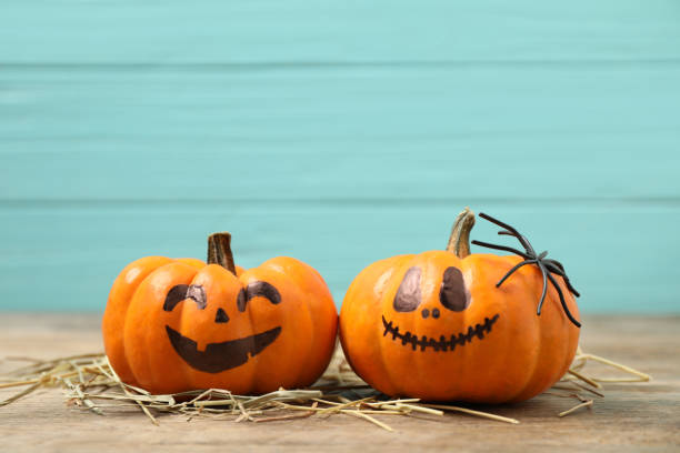 istock Pumpkins with scary faces on light blue wooden background, space for text. Halloween decor 1389149043