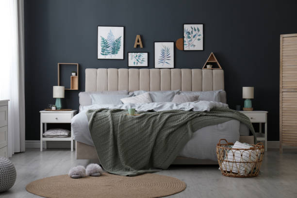 istock Comfortable bed with knitted green plaid in stylish room interior 1389149639