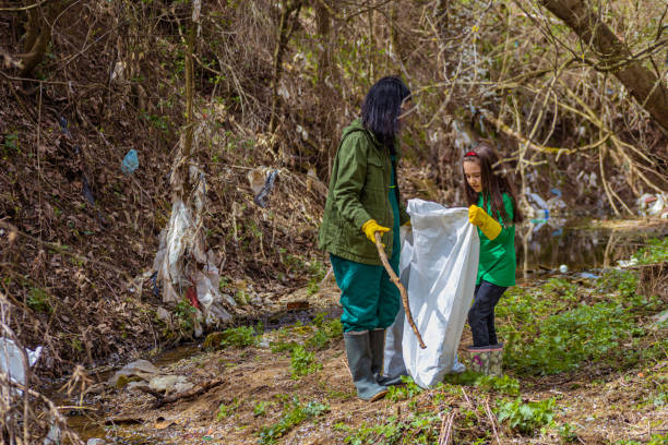 istock Mother and daughter collecting trash 1389152168