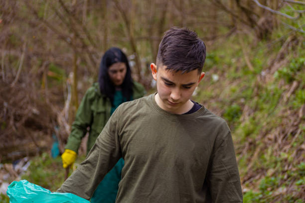 istock Mother and son cleaning nature from garbage 1389152760