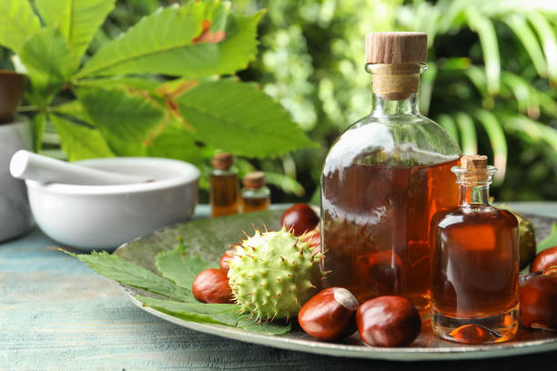 Chestnuts and bottles of essential oil on table against blurred background Chestnuts and bottles of essential oil on table against blurred background aesculus hippocastanum stock pictures, royalty-free photos & images