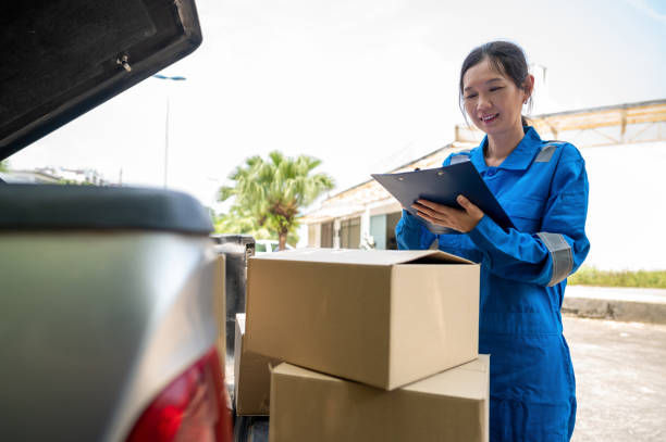 istock Cheerful female courier checking parcel boxes before making home delivery 1389153364
