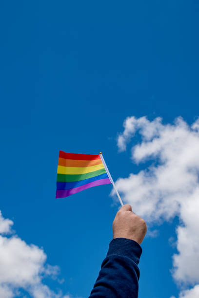 istock Holding gay pride symbol rainbow flag 1389153496
