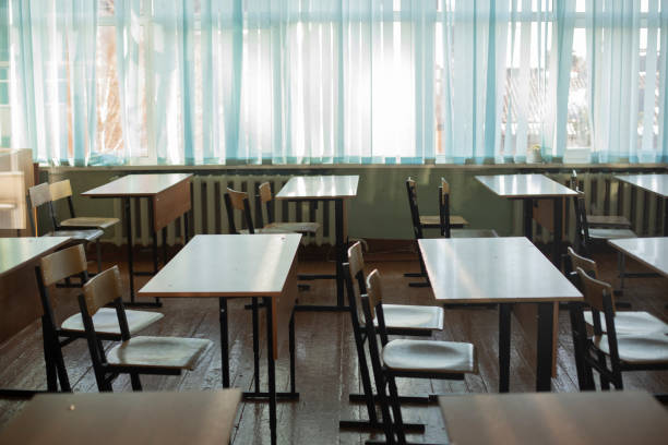 istock Desks for students at school. Classroom is empty. Chairs and tables are in row. 1389154636