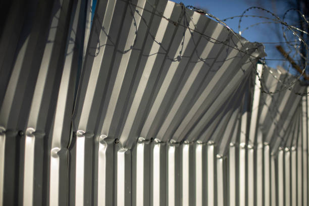 istock Broken fence. Fence from profile sheet bent. Rumpled iron. 1389154834