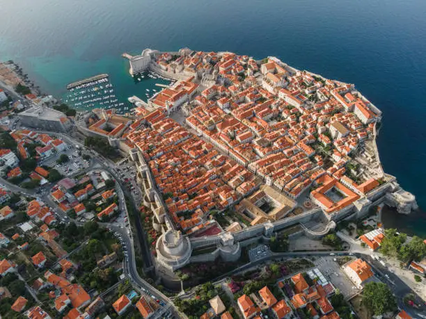 Photo of Dubrovnik, Croatia. Aerial view of the old town with rooftops and Adriatic sea.. Top view from drone