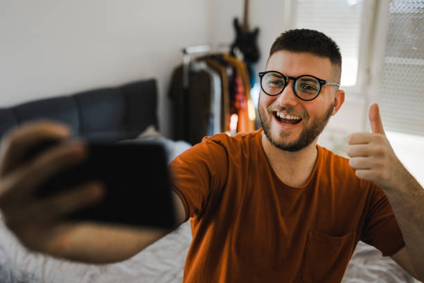 istock Man having video call by smart phone from his bedroom 1389161252