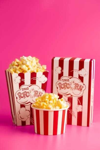istock Red and White Striped Popcorn Bucket Isolated on a Bright Pink Background 1389162657