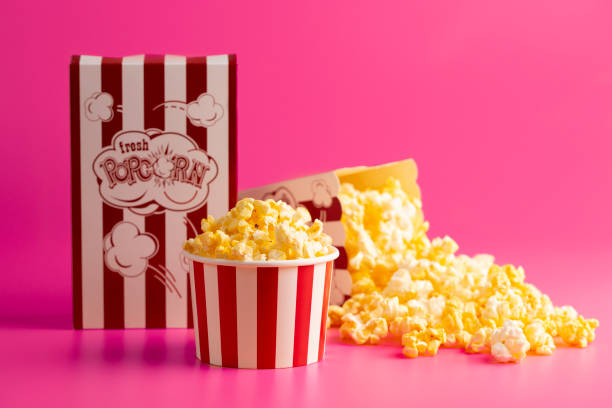 istock Red and White Striped Popcorn Bucket Isolated on a Bright Pink Background 1389162728