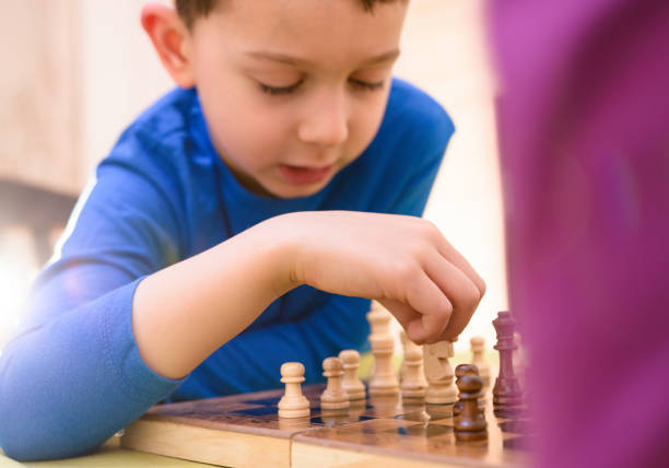 Little clever child. Concentration and thinking while playing chess on competition