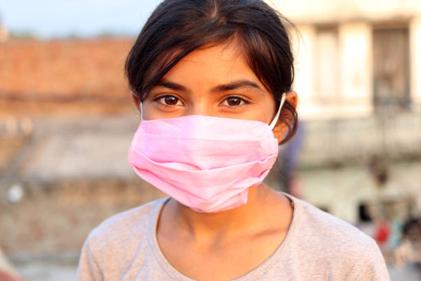 Teenager girl wearing protective face mask during pandemic portrait close up at home.