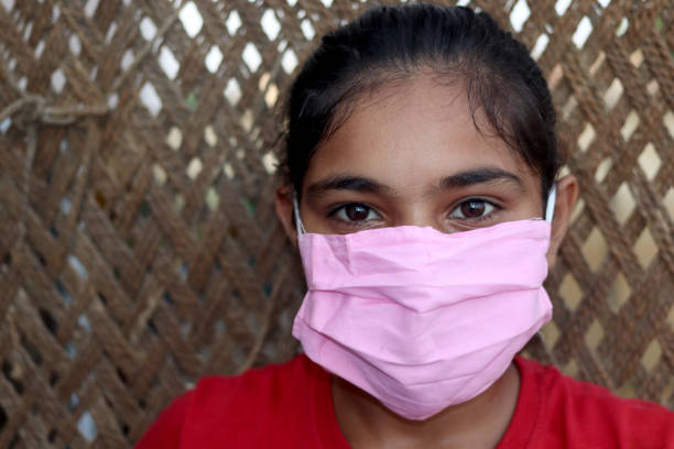 Teenager girl wearing protective face mask during pandemic portrait close up at home.