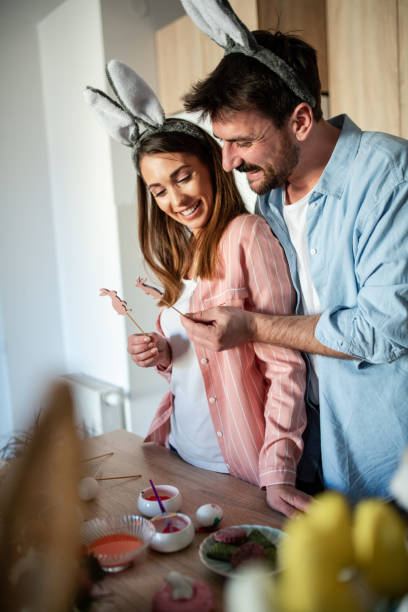 istock Young attractive couple laughing while wearing Easter bunny ears 1389168717