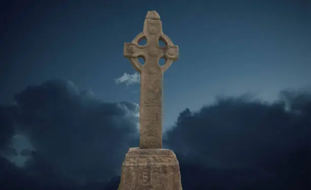 Photo of celtic cross in a cloudy night sky-