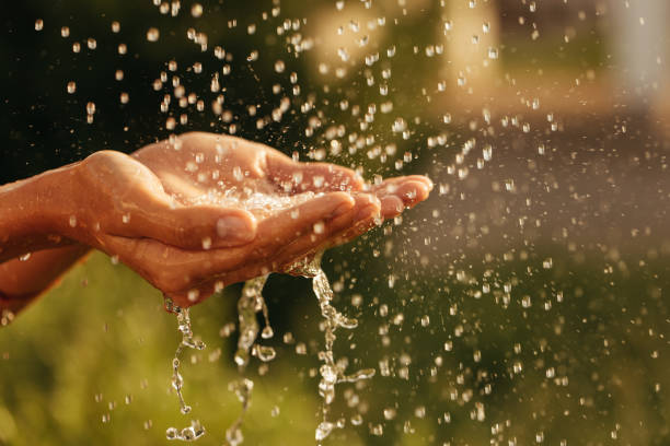 godersi l'estate. mani umane con schizzi d'acqua su di loro - catch light foto e immagini stock
