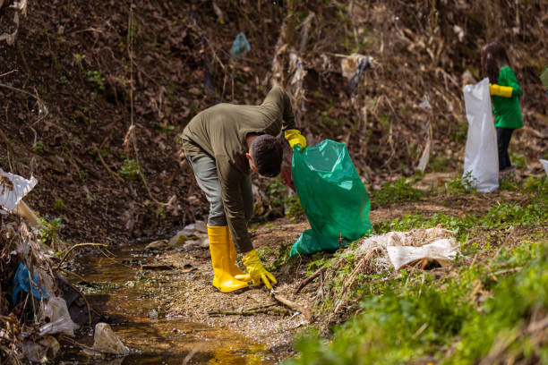 istock Brother and sister, picking up the garbage at the forest 1389176829