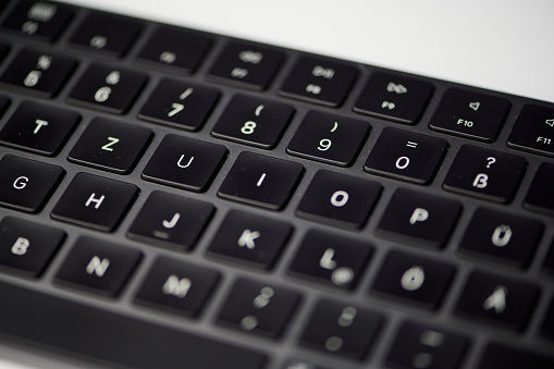 macro color photo of a black computer keyboard partly with blurred keys