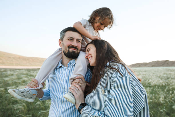 istock A hipster family walks in a summer field. 1389178247