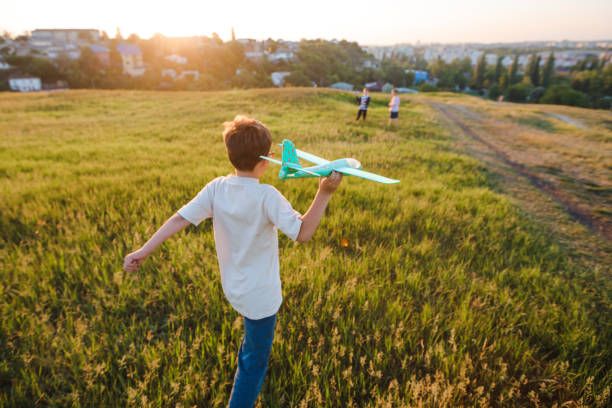 istock School-age boys launch a toy airplane. 1389178315