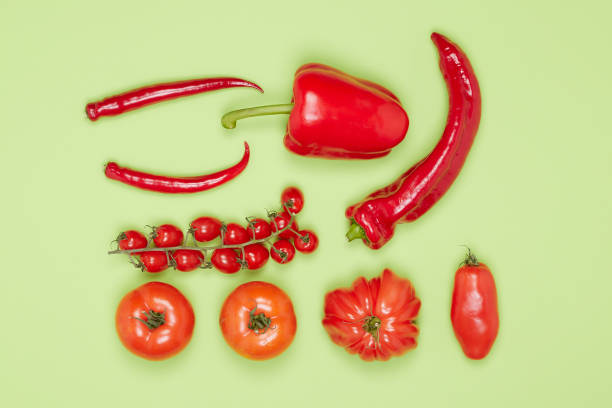 istock grouped vegetables with red peppers, pepperoni and tomatoes on a green background 1389179210