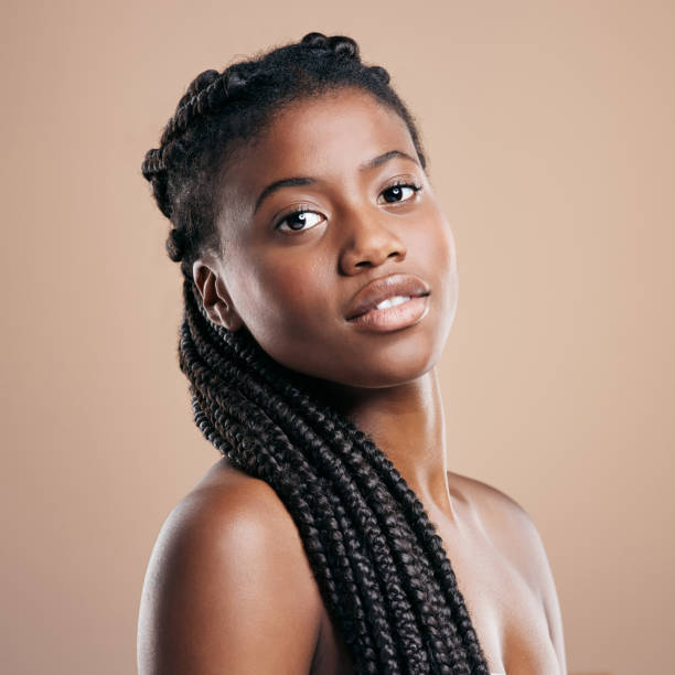 Cropped portrait of an attractive young woman posing in studio against a brown background My braids are my crown black hair braiding stock pictures, royalty-free photos & images