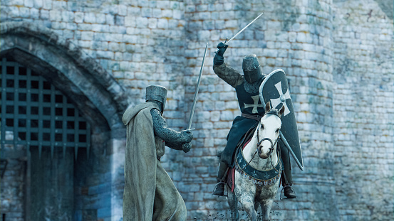 Two knights fight with swords in front of a castle