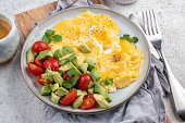Scrambled eggs with cherry tomatoes and avocado