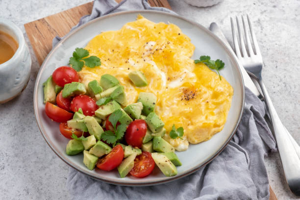 Scrambled eggs with cherry tomatoes and avocado Scrambled eggs omelet with cherry tomatoes and avocado omelet rustic food food and drink stock pictures, royalty-free photos & images