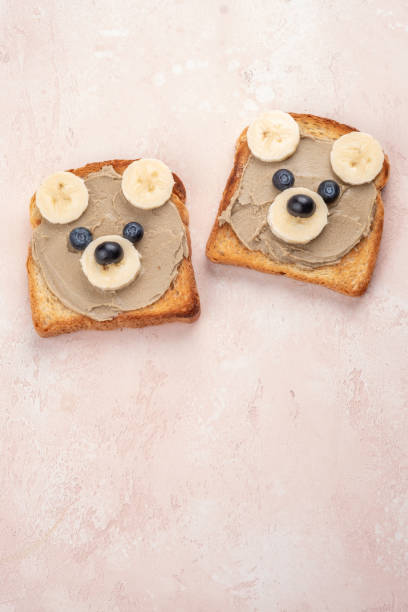 istock Funny children bear toasts with nuts butters for breakfast 1389185423