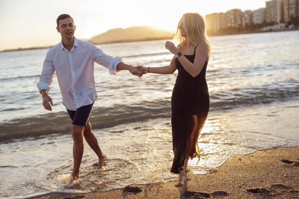 istock Carefree couple enjoying evening on beach together 1389187585