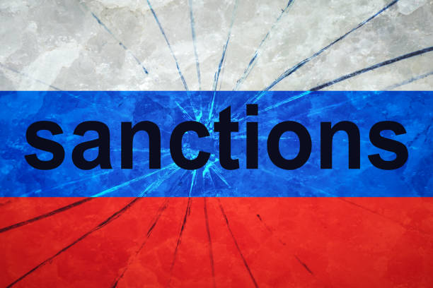 istock Russian flag on a broken glass texture with the inscription sanctions 1389188839
