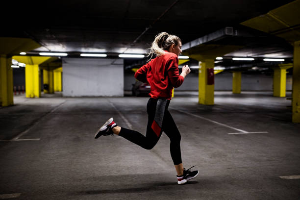 istock Young runner woman running in parking lot 1389188889