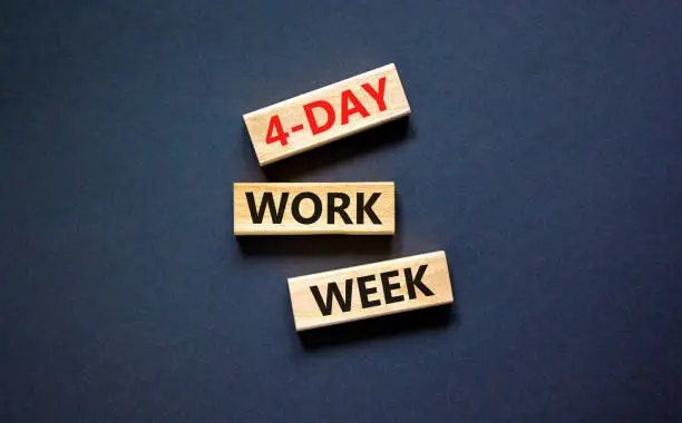 Photo of 4-day work week symbol. Concept words 4-day work week on wooden blocks on beautiful black table black background. Copy space. Business and 4-day work week and short workweek concept.