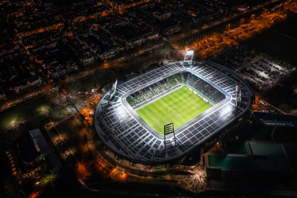 nachtluftaufnahme auf das beleuchtete weserstadion in bremen - uefa stock-fotos und bilder