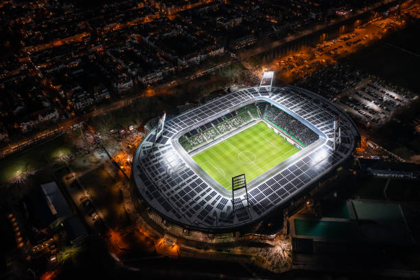 ночной вид с воздуха на освещенный везерштадион в бремене - uefa стоковые фото и изображения
