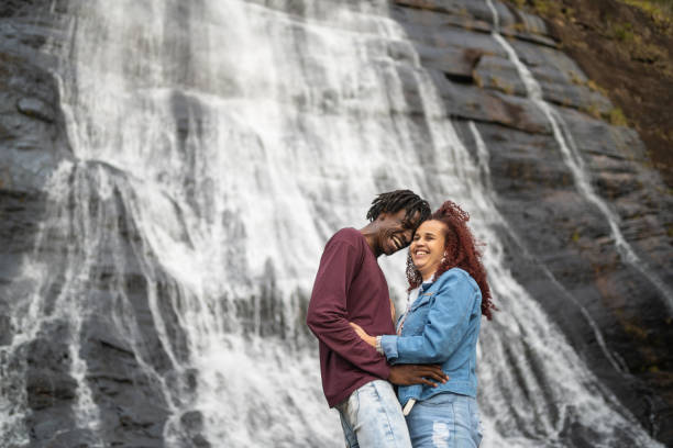 istock Couple smiling in front of waterfall 1389190644
