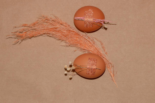 istock two eggs with small decorative flowers glued to them, Easter design on a vintage background with copy space, creatively arranged 1389193610