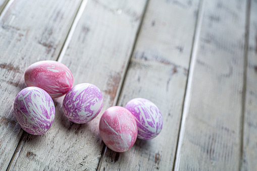 This is a photo of easter eggs that were silk dyed to create a unique delicate pattern on the eggs. The wood planks were painted white and sanded to create an old retro look.