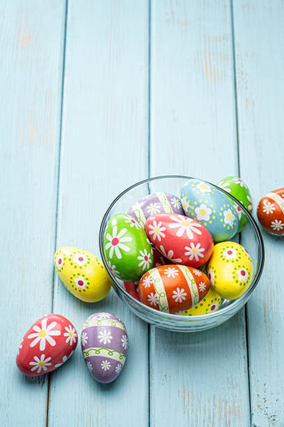 This is a overhead photo of easter eggs that were painted to create a unique delicate pattern on the eggs. The wood planks were painted light blue and sanded to create an old retro look. There is a lot of space above for copy.