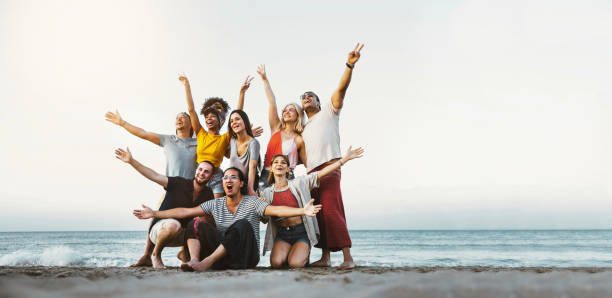 mejores amigos divirtiéndose juntos en la playa - grupo de jóvenes felices con los brazos en alto disfrutando de las vacaciones al aire libre - adolescentes disfrutando de la fiesta de vacaciones de primavera - vacaciones de verano - beach party friendship teenage girls fotografías e imágenes de stock