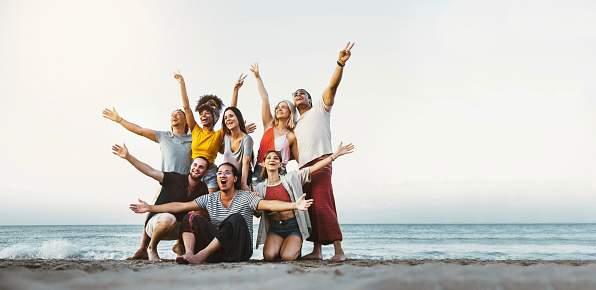 Best friends having fun together at the beach - Group of happy young people with arms up enjoying holiday outside - Teens enjoying spring break party - Summer vacations