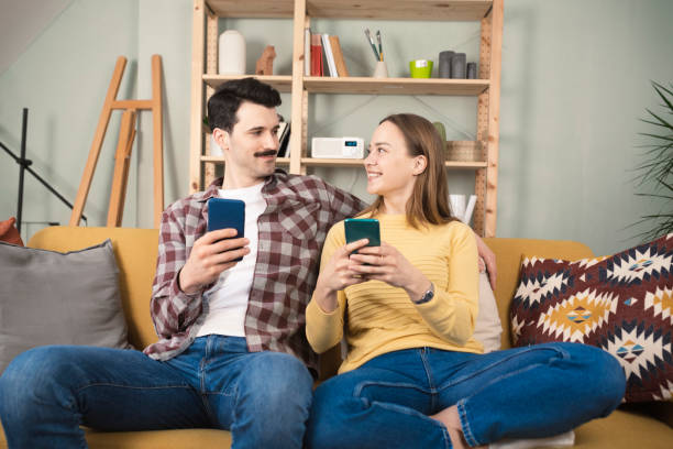 istock Happy couple using smartphone at home 1389202647